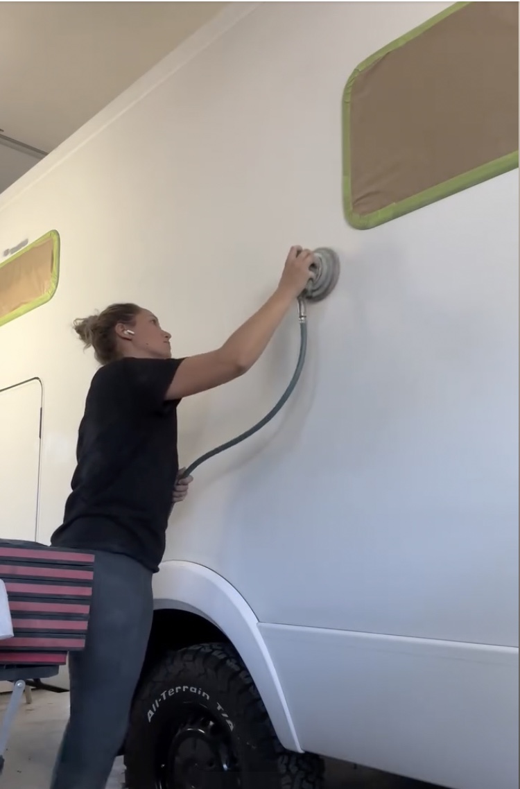 Chloé Bonnet travaillant sur la peinture d'un camping-car - La Carrosserie de Madame